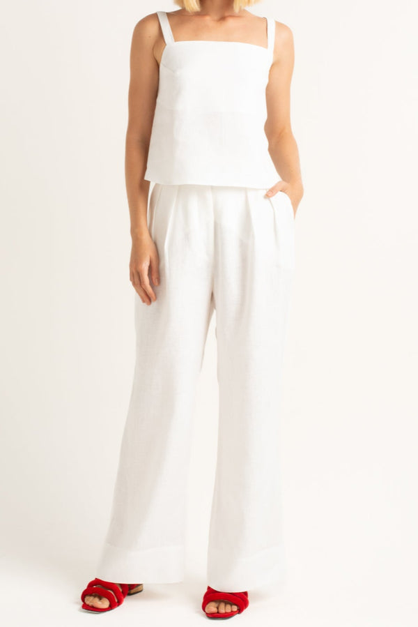Calça de alfaiataria off white em linho 100%, modelagem reta e pregas frontais.