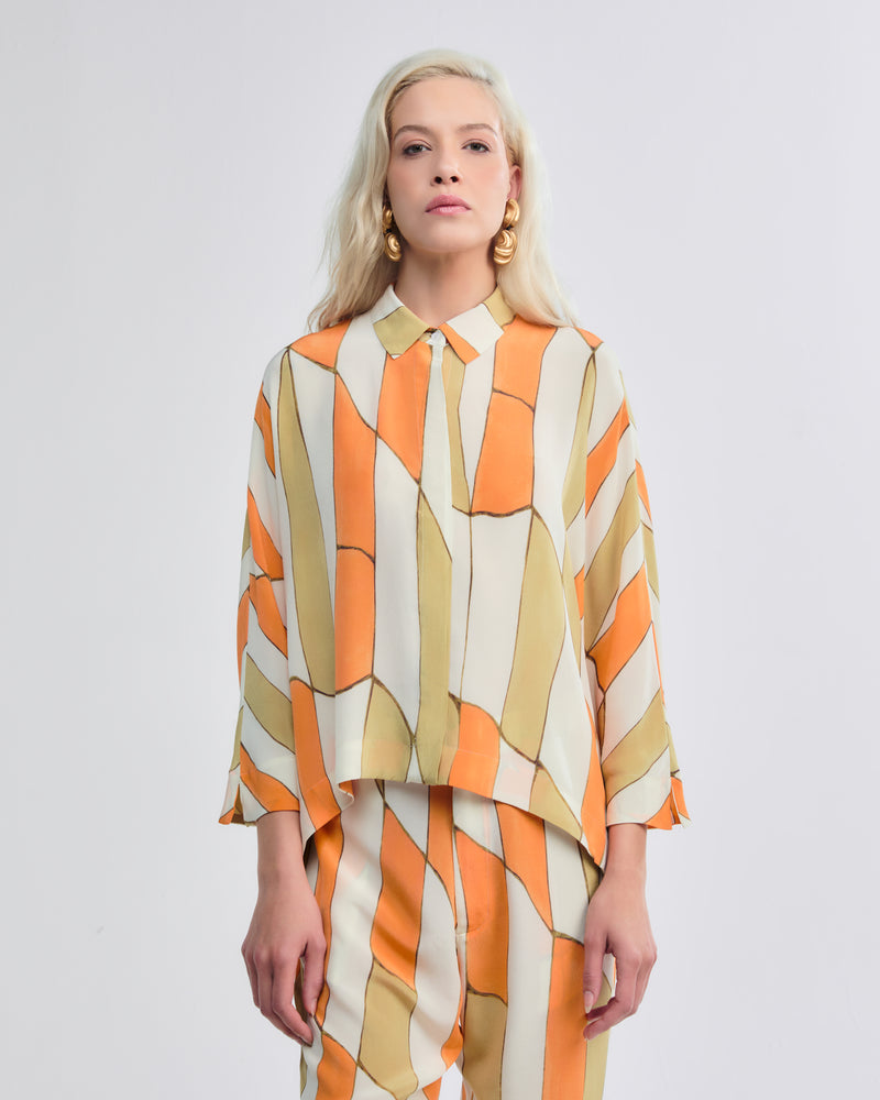 Camisa em crepe de chine 100% seda com estampa geométrica em bege, laranja e verde.