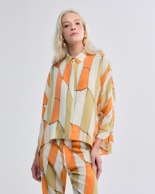 Blusa de seda com padronagem abstrata em tons quentes e modelagem solta.