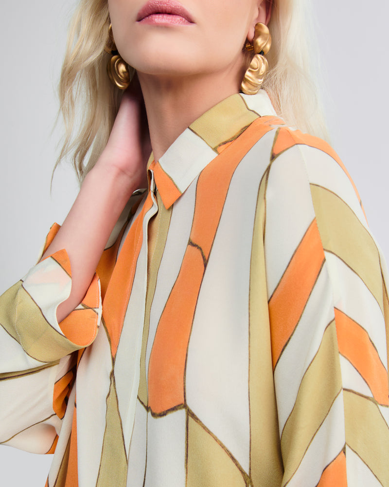 Camisa feminina sofisticada em seda estampada, gola clássica e fechamento frontal oculto.