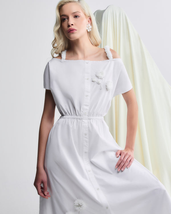 Vestido midi branco em algodão, com detalhes florais aplicados e cintura marcada por elástico.