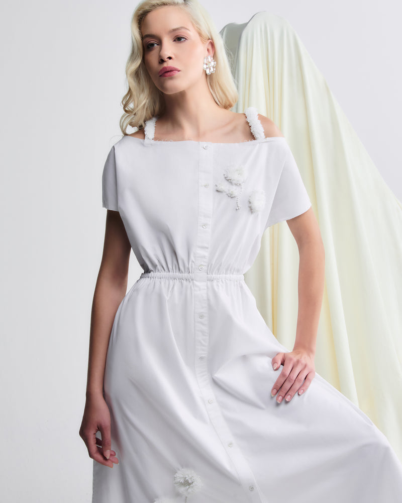 Vestido midi branco em algodão, com detalhes florais aplicados e cintura marcada por elástico.